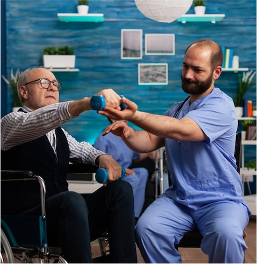 Physical therapist assisting senior in wheelchair with light weight exercises.